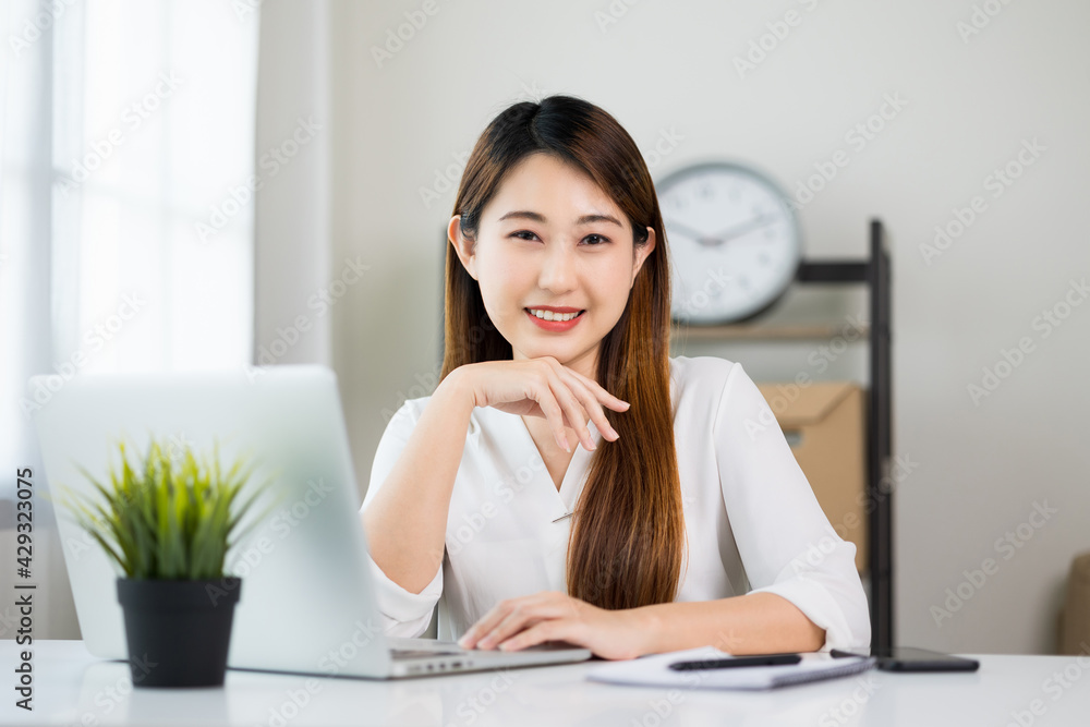Young asian beautiful business woman working with laptop sitting at home. Smiling charming happy young female doing homework meeting conference with team at home. Young asian beautiful business woman working with laptop sitting at home. Smiling charming happy young female doing homework meeting conference with team at home.