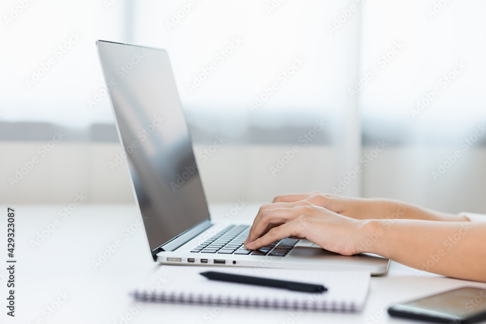 Close up female hand texting on laptop working on desk. Business woman working at home. Close up female hand texting on laptop working on desk. Business woman working at home.