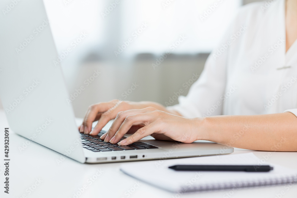 Close up female hand texting on laptop working on desk. Business woman working at home. Close up female hand texting on laptop working on desk. Business woman working at home.