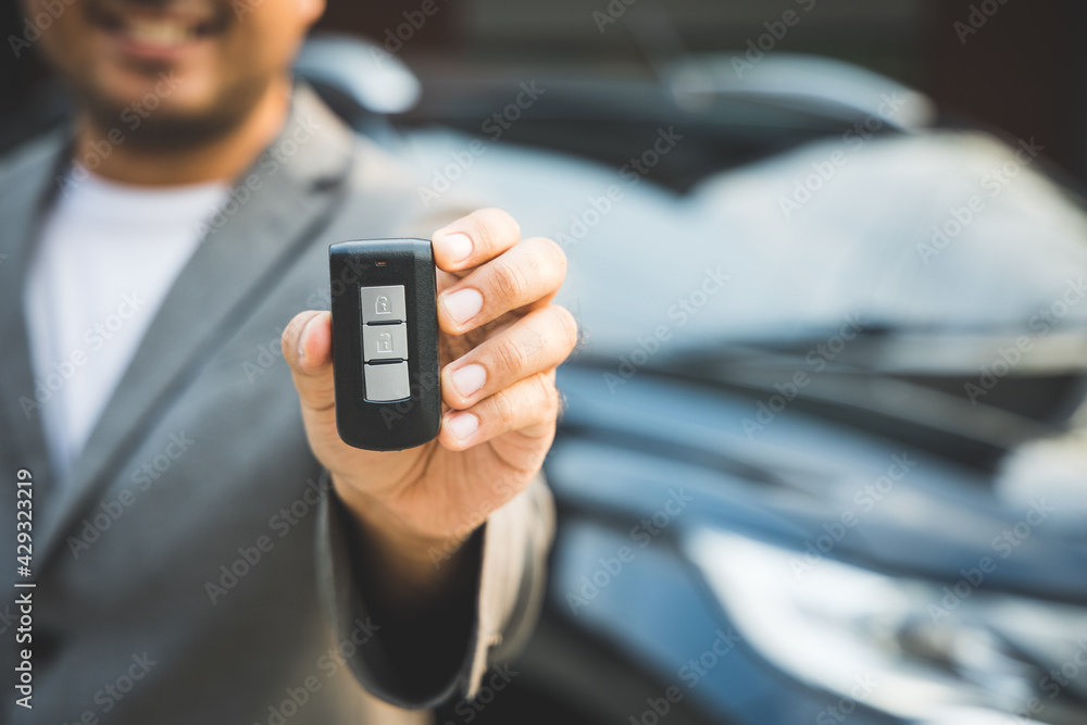Close up businessman in suit his hands showing or giving car key for customer getting new car. Buy sell rent car concept. Close up businessman in suit his hands showing or giving car key for customer getting new car. Buy sell rent car concept.