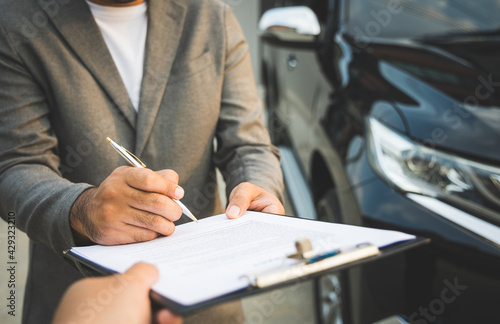 A young business man signs a luxury car leasing contract And sign a car insurance purchase contract on the documents according to the agreement