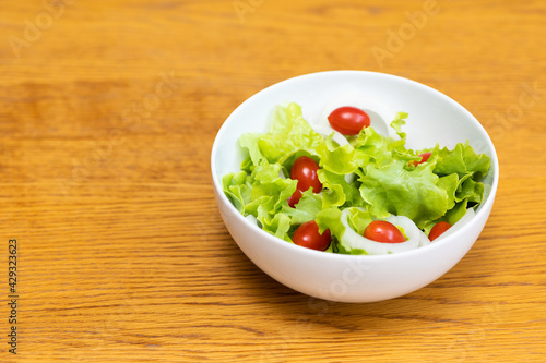Salad green oak and tomato. Breakfast diet menu. Fresh salad in morning on the wood table.