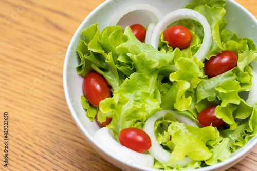 Salad green oak and tomato. Breakfast diet menu. Fresh salad in morning on the wood table.