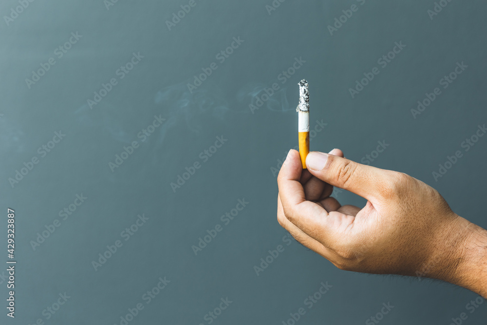 A young man with a cigarette He is going to smoke. It is dangerous to the people around. world tobacco day. A young man with a cigarette He is going to smoke. It is dangerous to the people around. world tobacco day.
