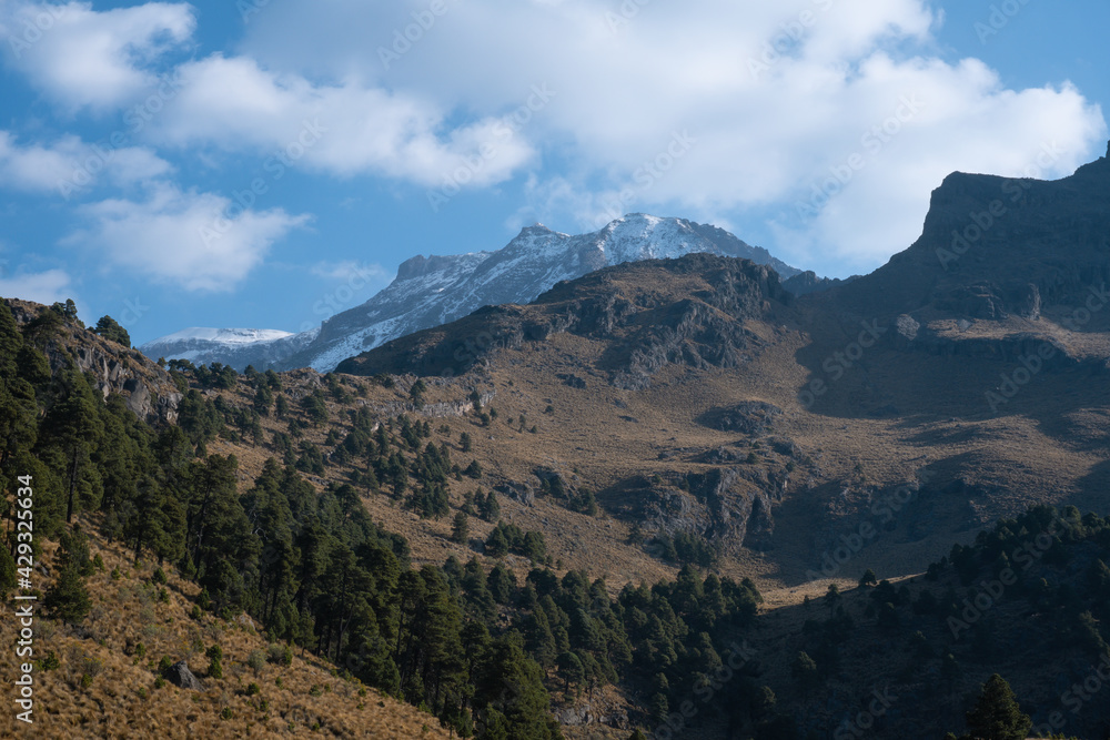 Fototapeta premium Stunning view of the snow-capped Iztaccihuatl volcanic mountain top in Mexico under a cloudy sky