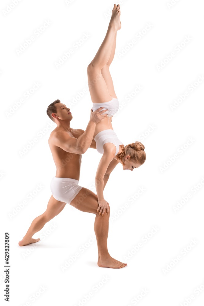 Man and woman practicing acro yoga together in studio Man and woman practicing acro yoga together in studio