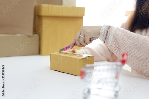 Woman unpacking unboxing after buying ordering online shopping at home