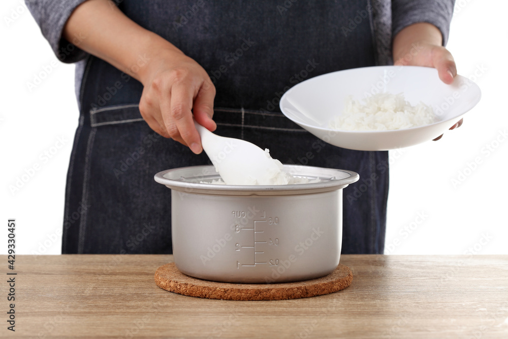 woman use rice spoon to scoop rice from pot on table woman use rice spoon to scoop rice from pot on table