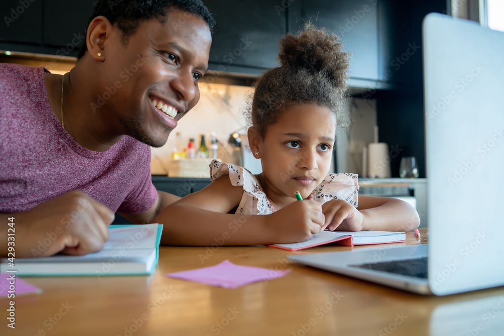 A father helping his daughter with homeschool. A father helping his daughter with homeschool.