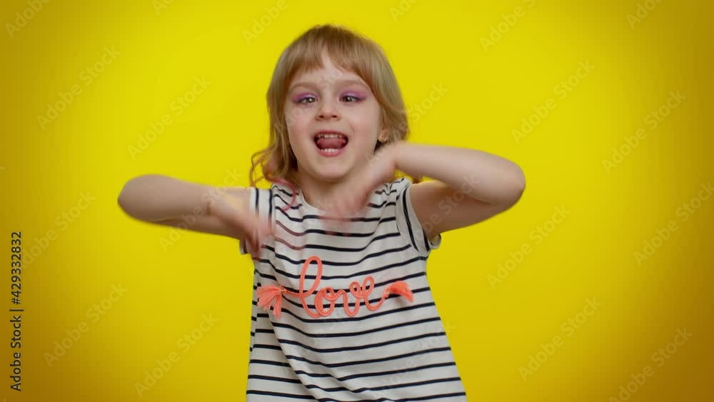 Playful funny little blonde kid child 5-6 years old demonstrating tongue out, fooling around, making silly faces, madness. Little bit crazy teenager children girl emotions on yellow studio background Playful funny little blonde kid child 5-6 years old demonstrating tongue out, fooling around, making silly faces, madness. Little bit crazy teenager children girl emotions on yellow studio background