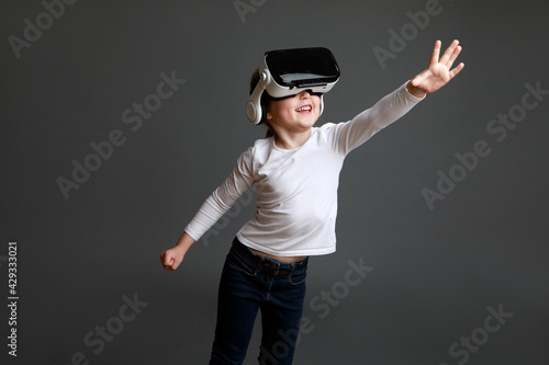 Kid with virtual reality headset, studio shot isolated on grey background