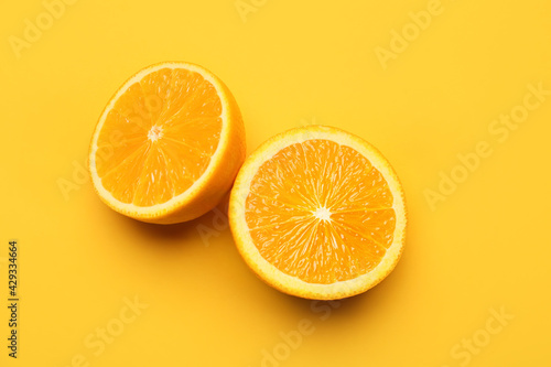 Pieces of fresh orange fruit on color background