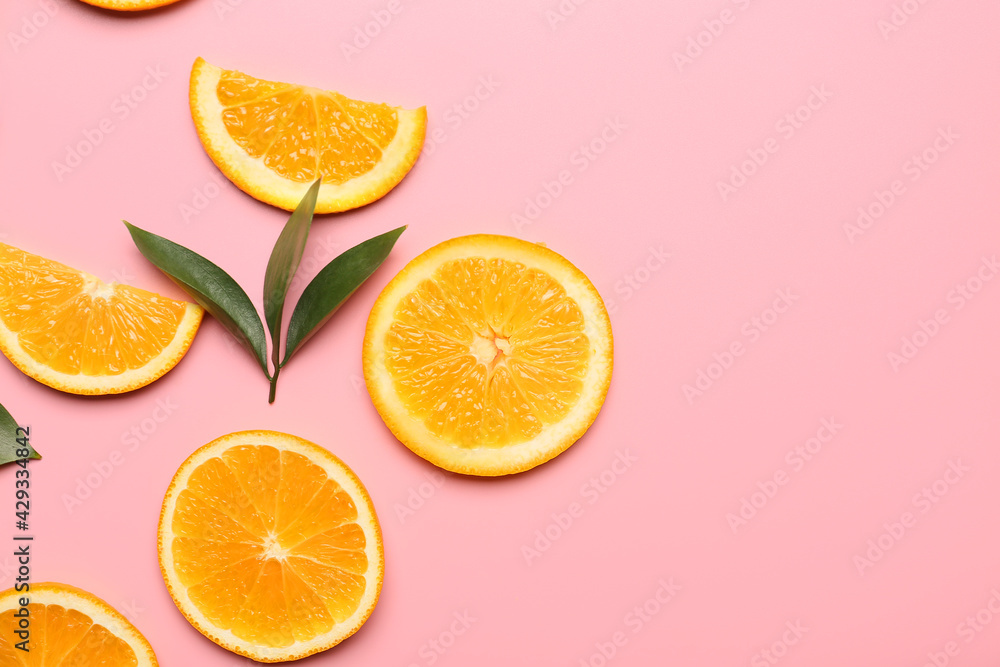 Slices of fresh oranges with green leaves on color background Slices of fresh oranges with green leaves on color background
