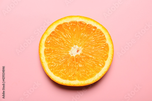 Piece of fresh orange fruit on color background