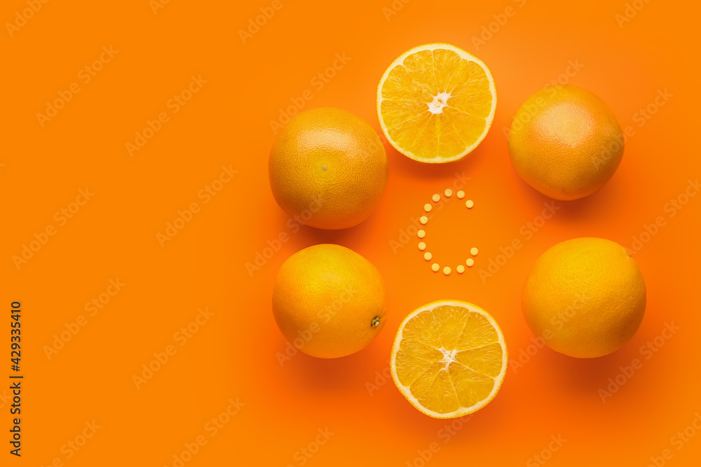 Composition with vitamin C pills and oranges on color background Stock