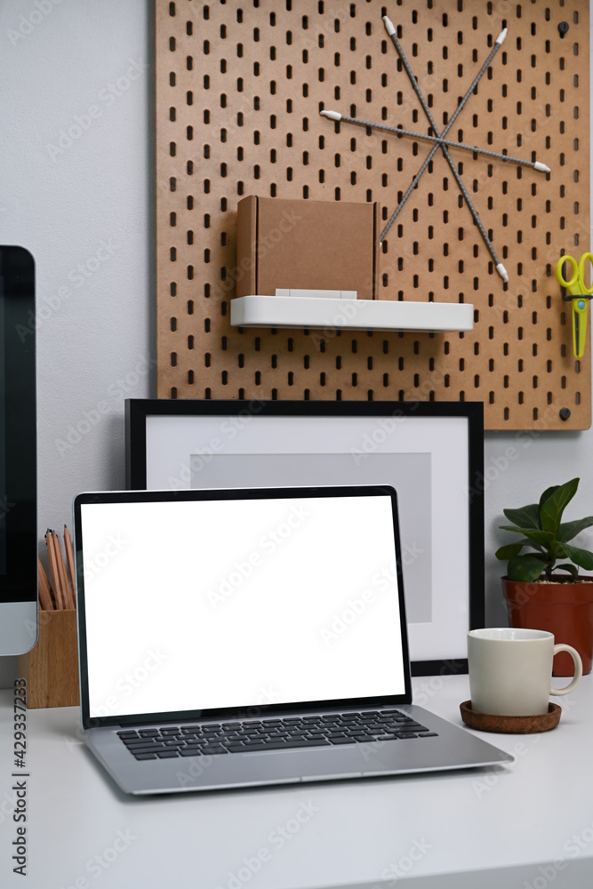 Mock up computer laptop with blank screen and office supplies on white desk at modern home office. Mock up computer laptop with blank screen and office supplies on white desk at modern home office.