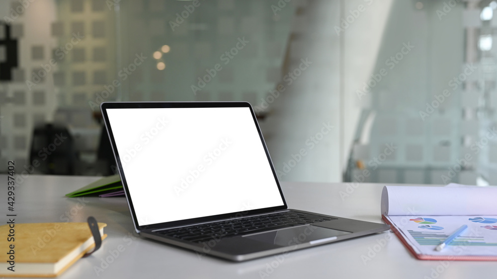 Mock up computer laptop with blank screen, paperwork and notebook on white office desk. Mock up computer laptop with blank screen, paperwork and notebook on white office desk.
