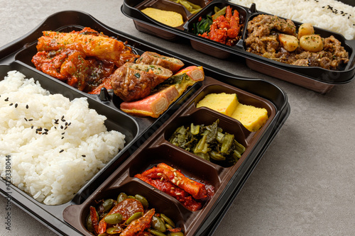 Lunch box with rice, meat and vegetable side dishes