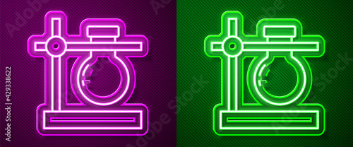 Glowing neon line Glass test tube flask on stand icon isolated on purple and green background. Laboratory equipment. Vector