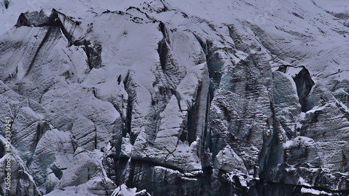 Closeup view of the breakoff edge of Sólheimajökull, an outlet glacier of Mýrdalsjökull (Katla), in the south of Iceland with ice surface of white and black pattern and crevasses in winter season. photo
