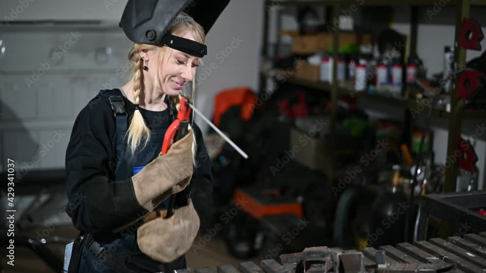 Video of a woman welder working in a mask in the industry Video of a woman welder working in a mask in the industry