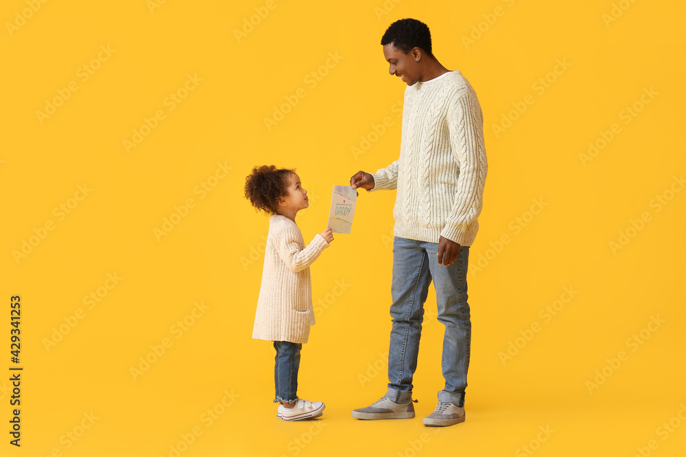 Cute African-American girl greeting her dad on Father's Day against color background Cute African-American girl greeting her dad on Father's Day against color background