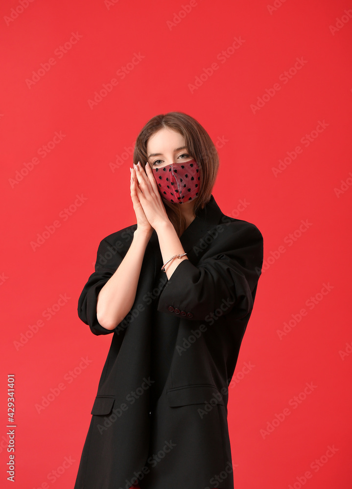 Fashionable young woman wearing mask on color background Fashionable young woman wearing mask on color background