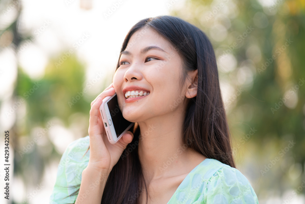 Portrait of asian beautiful women talking on smartphone in outdoor park Portrait of asian beautiful women talking on smartphone in outdoor park