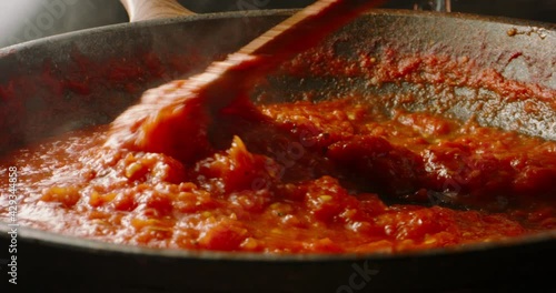 Italian tomato sauce is boiling and stirring in a pan for pizza or pasta, 4k footage