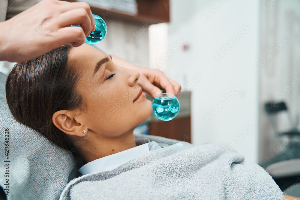 Lovely client dozing during a cosmetic procedure - obrazy, fototapety, plakaty 
