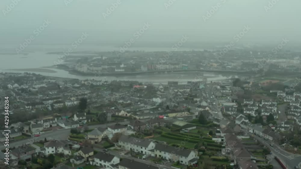 Aerial still establishing shot of rural city by the sea on overcast day Aerial still establishing shot of rural city by the sea on overcast day
