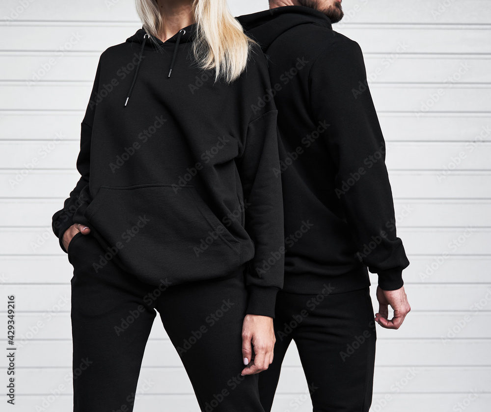 Woman and man wear black hoodie without a logo. No logo basic sportswear.  Long sleeve sweatshirt mockup Stock Photo | Adobe Stock