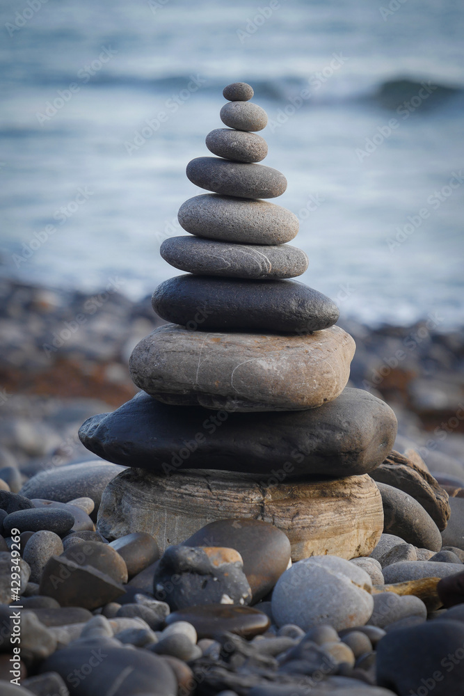 Stone piles made along a beach and the sea in the background. High quality photo