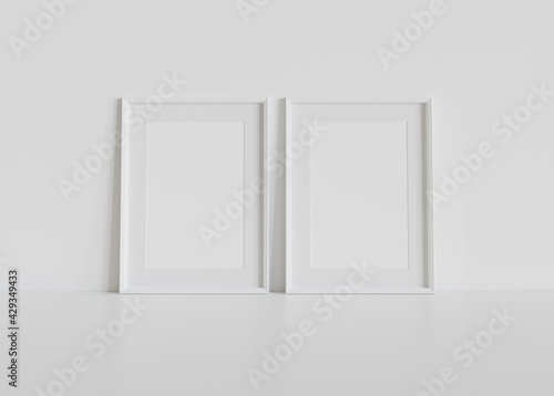 Two white frames leaning on white floor in interior mockup. Template of pictures framed on a wall 3D rendering