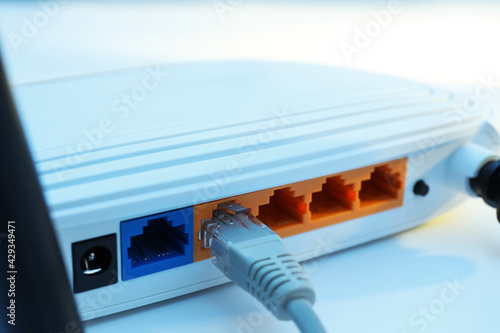 Connected cable to router on white table, closeup. Wireless internet communication