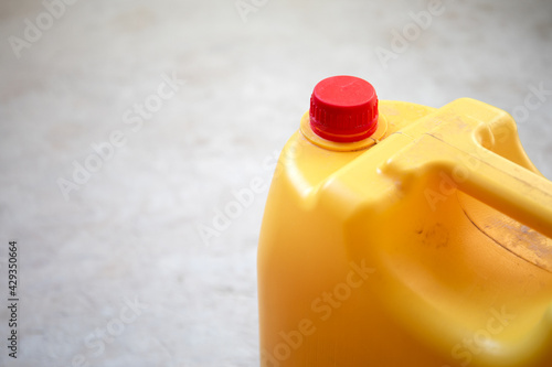 Yellow plastic container with a red stopper. Building materials and chemical products