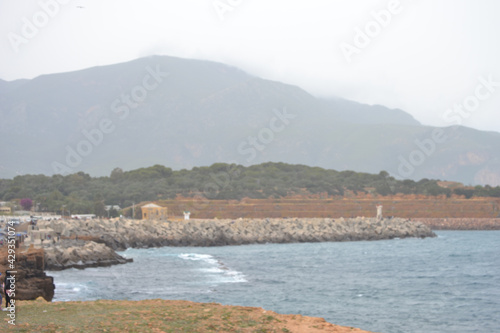 Tranquil view of the rocky coastline by the ocean on a misty day photo