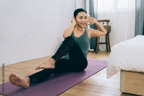 vigorous asian woman strengthening her immune system by working out regularly. korean female protecting her health and helping herself stay calm during self-quarantine through physical activity