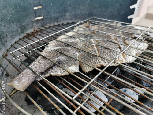 Detailed view of fish grilled over a burning coal fire, healthy and typically Mediterranean food