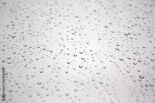 textured appearance formed by large and small water droplets formed on the white glass
