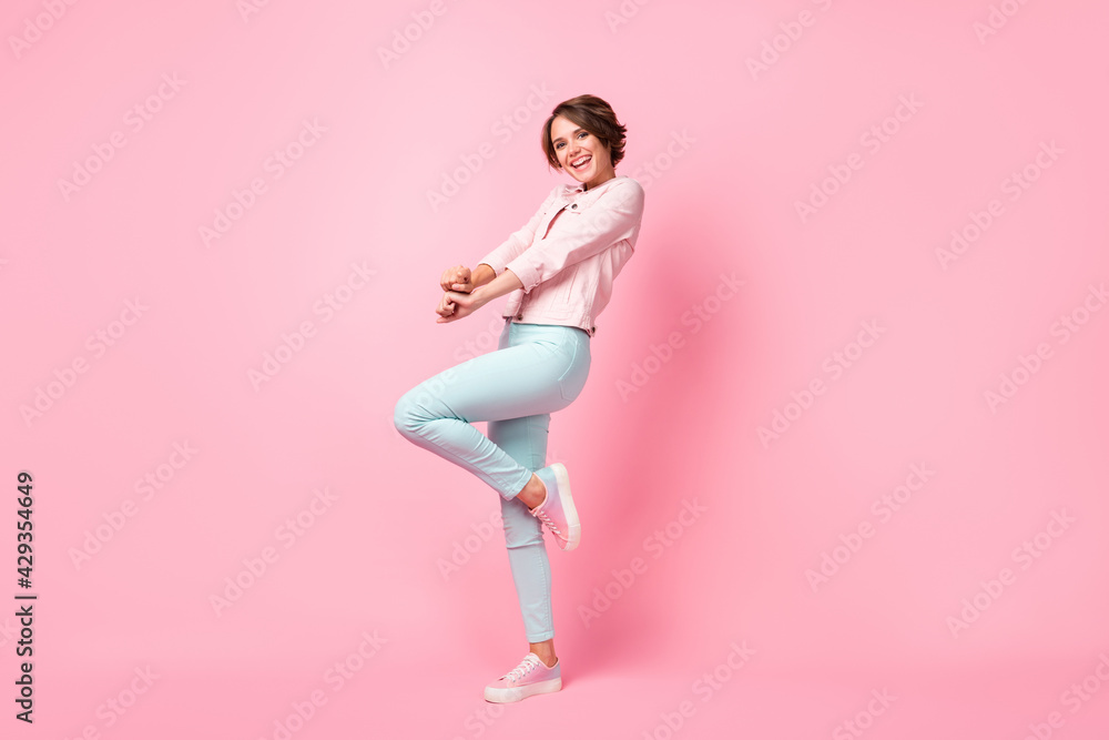 Full length photo portrait of cute girl standing on one leg isolated on pastel pink colored background