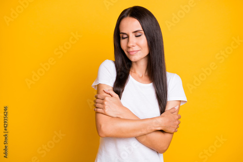 Photo portrait of sensual woman wearing white clothes embracing herself closed eyes isolated on vivid yellow color background with copyspace