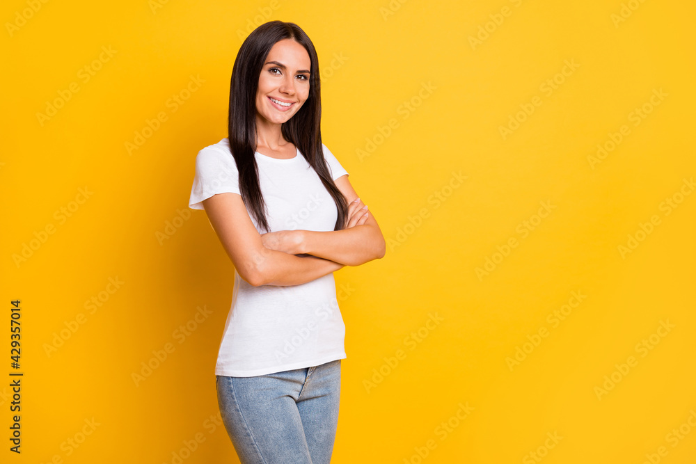 Photo portrait of brunette girl wearing casual clothes smiling with folded hands isolated on vibrant yellow color background Photo portrait of brunette girl wearing casual clothes smiling with folded hands isolated on vibrant yellow color background
