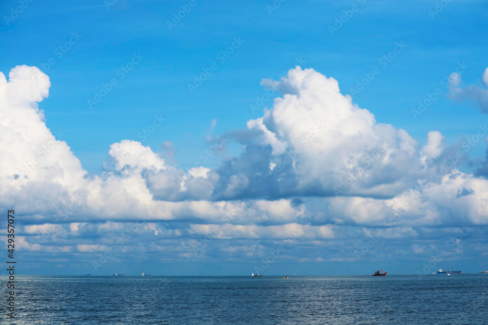 Obraz premium pure clear blue sky huge white gray cloud and sunlight shiny on tropical on the sea and fishing boat