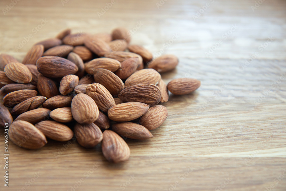 Crude almonds nuts on wooden background. Side view Crude almonds nuts on wooden background. Side view