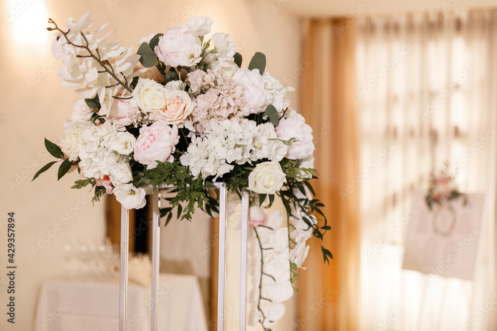 Festive Floral decor on wedding banquet tables in white colors with cutlery Festive Floral decor on wedding banquet tables in white colors with cutlery
