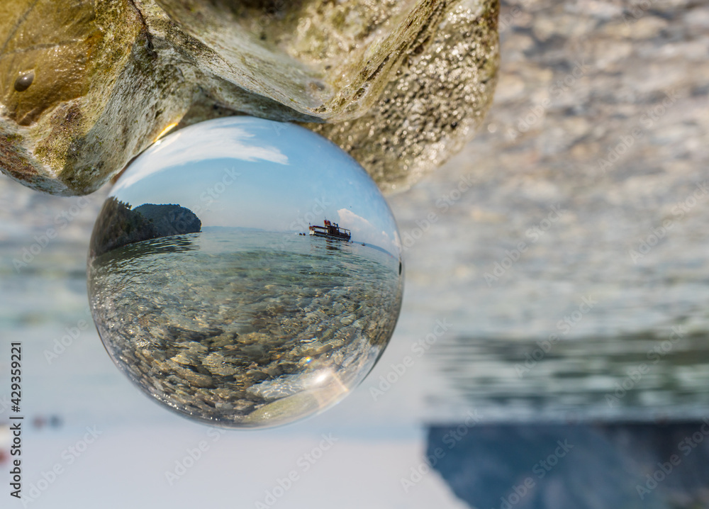 CCrystal ball in the man’s hand. Original upside down view and rounded perspective of the sky, sea and boat. CCrystal ball in the man’s hand. Original upside down view and rounded perspective of the sky, sea and boat.