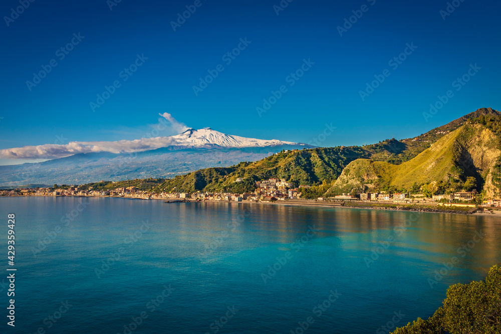 Beauty on the coast of Taormina, marvelous turquoise water and snowy mountains in the background 