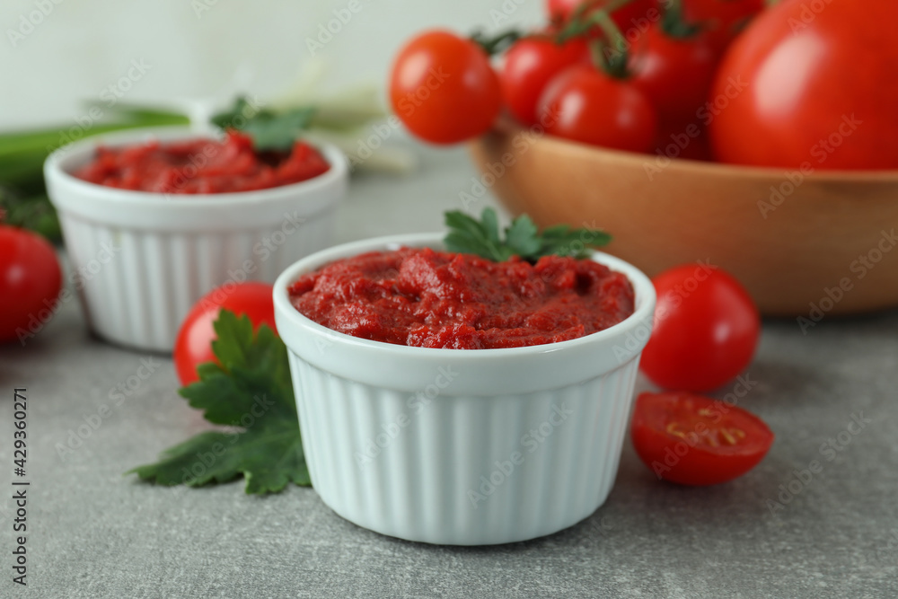 Bowls with tomato paste on gray background with ingredients Bowls with tomato paste on gray background with ingredients