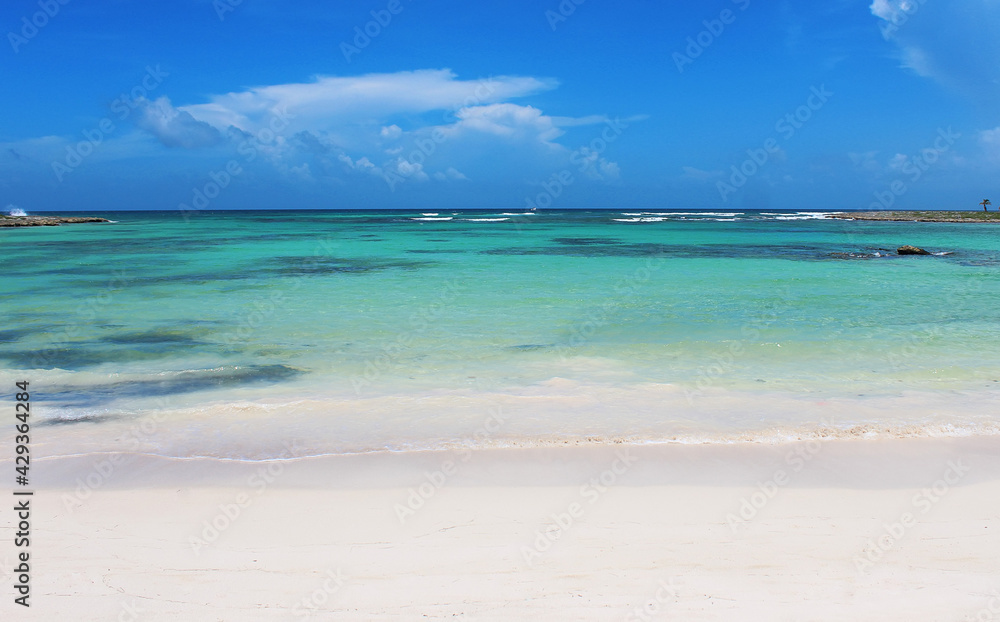 Beautiful white sandy beach and turquoise waters of Caribbean sea in summer sunny day. Caribbean coast in the Playa del Carmen, Riviera Maya, Quintana Roo, Mexico. Soft focus
